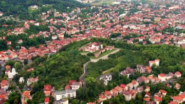 Aerial drone view of The Citadel in Brasov, Romania. Medieval fortress on the top of a hill. Buildings and green trees around