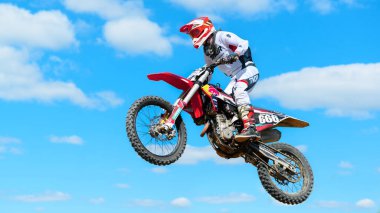 CHISINAU, MOLDOVA - SEPTEMBER, 2022: Motokros yarışında zıplayan bir motosikletlinin görüntüsü, çamur pisti, rali motosikleti, arka planda gökyüzü