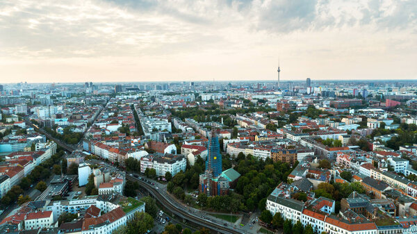 Aerial drone view of Kreuzberg, Berlin, Germany. Residential district with greenery, Cathedral, buildings and Berlin Television Tower in the distance