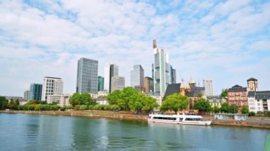 FRANKFURT, Almanya - 11 Eylül 2022: Frankfurt şehir merkezi, Almanya. Nehir kıyısı demirli tekne, arka planda gökdelenler.