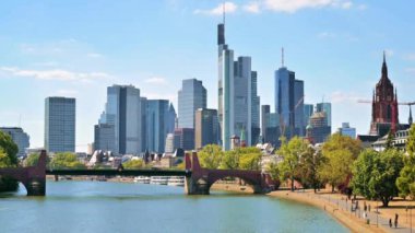 FRANKFURT, Almanya - Eylül 2022 Frankfurt şehir merkezi, Almanya. Köprüsü ve demirlemiş tekneleri olan River Main, arka planda gökdelenler, yürüyen insanlar.