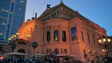 FRANKFURT, ALMANY - Eylül 2022: şehir merkezinin gün batımında sokak manzarası. Alte Oper ile Opernplatz, arka planda dinlenen insanlar ve gökdelen