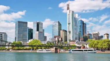 Frankfurt şehri, Almanya 'da. Köprüsü ve demirli tekneleri olan River Main, arka planda gökdelenler, diğer binalar.