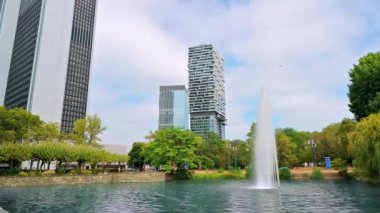 Frankfurt 'un sokak manzarası, Almanya. Meydanı yeşillik, çeşme, gölet ve gökdelenlerle dolu.