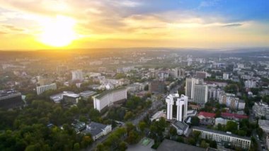 Chisinau 'nun günbatımında Moldova' da hava aracı görüntüsü. Belediye başkanlığı ve parlamentoyla şehir merkezi manzarası, birden fazla bina, yollar, yemyeşil, şehir manzarası