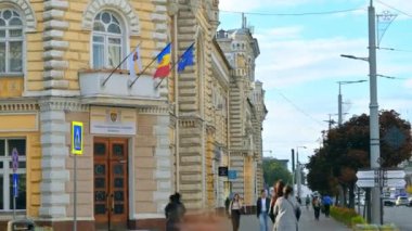 CHISINAU, MOLDOVA - Eylül 2022: Şehir merkezinin zaman gösterimi. Belediye binasında birden fazla yürüyen insan var.
