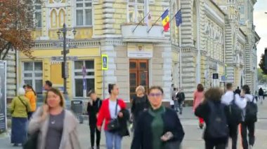 CHISINAU, MOLDOVA - Eylül 2022: Şehir merkezinin zaman gösterimi. Belediye binasında birden fazla yürüyen insan var.