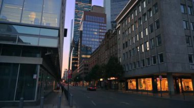 FRANKFURT, ALMANY - 11 Eylül 2022: gün batımında şehrin sokak manzarası. Klasik binalar, gökdelenler, yürüyen insanlar.