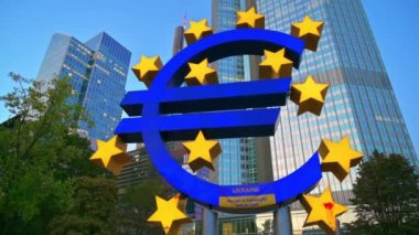 FRANKFURT, GERMANY - 11 Eylül 2022: Frankfurt, Almanya 'da arka planda birden fazla gökdelenli The Euro-Skulptur' un yakın görüntüsü. Üzerinde Ukrayna bayrağı ve kan var.