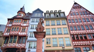 Frankfurt, Almanya 'da Roemerberg' de bulunan bir heykel. Arka planda yarı ahşap binalar var.