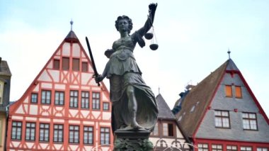 Adalet Pınarı, Almanya 'nın Frankfurt kentindeki Roemerberg' de bulunmaktadır. Arka planda yarı ahşap binalar var.
