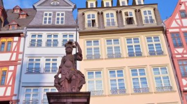 Frankfurt, Almanya 'da Roemerberg' de bulunan bir heykel. Arka planda yarı ahşap binalar var.