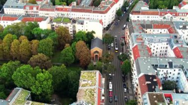 Berlin, Almanya 'nın insansız hava aracı görüntüsü. Yeşillikleri, binaları ve hareket halindeki arabaları olan yolları olan yerleşim yerleri.