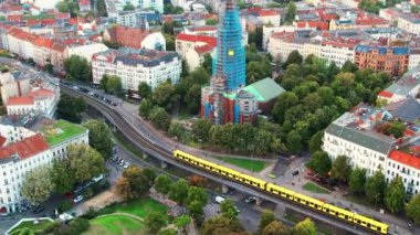 Kreuzberg, Berlin, Almanya 'nın insansız hava aracı görüntüsü. Yeşillik, katedrallik, hareket halindeki trenler ve binaların bulunduğu yerleşim bölgesi.