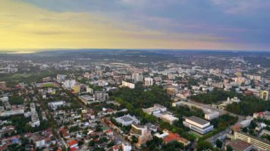 Chisinau 'nun günbatımında Moldova' da hava aracı görüntüsü. Başkanlığı ve parlamentosu olan şehir merkezi manzarası, birden fazla bina, yollar, yemyeşil
