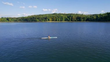 CHISINAU, MOLDOVA - Eylül 2022 Valea Morilor parkının insansız hava aracı görüntüsü. Yeşillik, göl, kayak yapan bir adam.