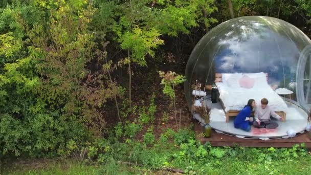 Transparent Bubble Tent Glamping Lush Forest Interior Couple Sitting Blanket — Stock Video