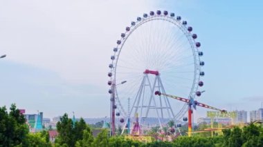 Türkiye 'nin Antalya kentinde dönme dolabı olan bir lunapark manzarası. Arkaplanda şehir manzarası