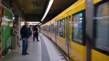 BERLİN, ALMANY - Eylül 2022: Durmuş trenin ve insanların inip girdiği bir yeraltı istasyonunun içi