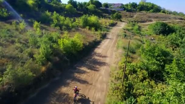 Chisinau Moldova 2022年9月 自転車レース ラリーバイク 緑豊かな周辺でスプリングボードから飛び降りるオートバイの空中ドローンビュー — ストック動画