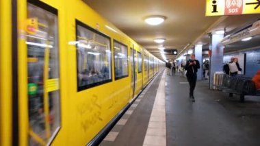 BERLİN, GERMANY - EYLÜL, 2022: Trenle ve yürüyen insanlarla dolu bir yeraltı istasyonunun içi