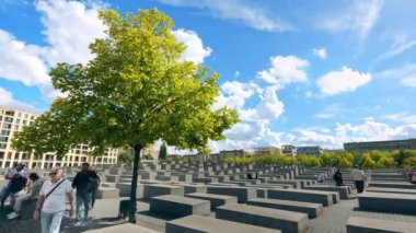 BERLİN, ALMANY - Eylül 2022: Öldürülen Avrupa Yahudileri Anıtı 'nın Zaman Çizelgesi. İçinde insanlar ve birkaç yeşil ağaç olan dikdörtgen beton bloklar.