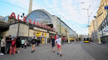 BERLİN, ALMANY - Eylül 2022: Alexanderplatz Timelapse sokak manzarası. Meydanda birden fazla insan, modern binalar, restoranlar, tramvaylar