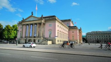 BERLİN, ALMANY - Eylül 2022: Bebelplatz 'ın yakınındaki Devlet Operası manzarası. Yürüyen arabalar ve yürüyen insanlarla dolu bir yol.