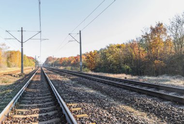 Raylara alçak bir perspektiften bakmak, raylara yakın çekim yapmak ve uykuculuk yapmak. Uzun pist inşaatı. Taşlar ve demiryolu uyuyanları yere yığıldı. Rayları tutan vidaların yakın çekimi..