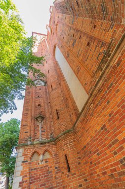 Kırmızı tuğladan yapılmış birkaç yüzyıl katedralinin duvarları. Büyük katedral binası, ibadet yeri, ayin. Sağlam tuğla duvar, inanılmaz bir yapı..