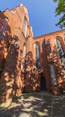 Kırmızı tuğladan yapılmış birkaç yüzyıl katedralinin duvarları. Büyük katedral binası, ibadet yeri, ayin. Sağlam tuğla duvar, inanılmaz bir yapı..