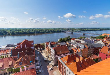 Sıcak bir yaz günü yukarıdan eski Torun kasabası ve Vistula nehri manzarası. Binaların kırmızı tuğlalı çatılarının manzarası.
