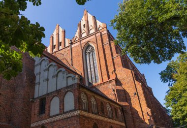 Kırmızı tuğladan yapılmış birkaç yüzyıl katedralinin duvarları. Büyük katedral binası, ibadet yeri, ayin. Sağlam tuğla duvar, inanılmaz bir yapı..