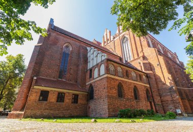 Kırmızı tuğladan yapılmış birkaç yüzyıl katedralinin duvarları. Büyük katedral binası, ibadet yeri, ayin. Sağlam tuğla duvar, inanılmaz bir yapı..