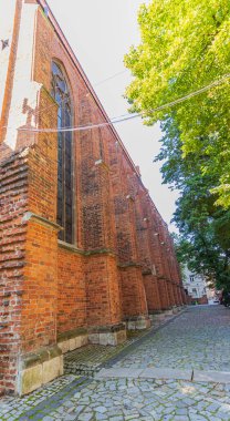 Kırmızı tuğladan yapılmış birkaç yüzyıl katedralinin duvarları. Büyük katedral binası, ibadet yeri, ayin. Sağlam tuğla duvar, inanılmaz bir yapı..