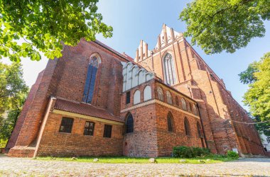 Kırmızı tuğladan yapılmış birkaç yüzyıl katedralinin duvarları. Büyük katedral binası, ibadet yeri, ayin. Sağlam tuğla duvar, inanılmaz bir yapı..