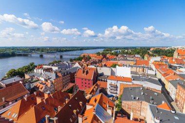 Sıcak bir yaz günü yukarıdan eski Torun kasabası ve Vistula nehri manzarası. Binaların kırmızı tuğlalı çatılarının manzarası.
