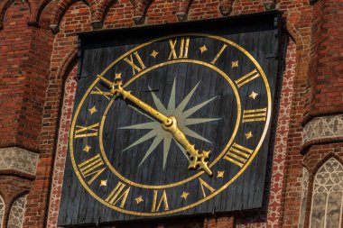 view of the high clock tower in the city of Torun. high structure of the tower with a clock showing the time,