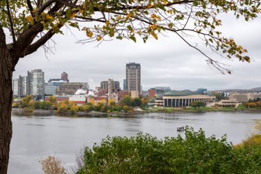Ottawa, Kanada - 14 Ekim 2021: Ottawa Nehri ve Kanada 'nın Quebec kentinin panoramik manzarası. Binbaşı 'nın Tepe Parkı' ndan sonbahar sezonunda ağaçlar ön plandayken şehir manzarası. Kanada Tarih Müzesi.