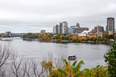 Ottawa, Kanada - 14 Ekim 2021: Ottawa, Ontario ve Gatineau arasındaki Portage Köprüsü, Kanada. Sonbahar mevsiminde Major 's Hill Park' tan şehir manzarası renk değiştiren ağaçlarla dolu..