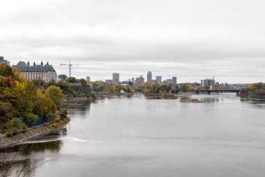 Ottawa, Kanada - 14 Ekim 2021: Ottawa, Ontario ve Gatineau arasındaki Portage Köprüsü, Kanada. Sonbahar sezonunda Major 's Hill Park' tan şehir manzarası. Victoria Adası. Parlamento Tepesi