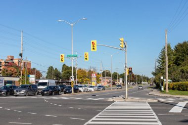 Ottawa, Kanada - 6 Ekim 2021: Ottawa 'daki Baseline ve Greenbank yollarının kesiştiği yerde güneşli bir mevsimde trafik ışıkları, yaya geçidi ve caddelerdeki arabalar