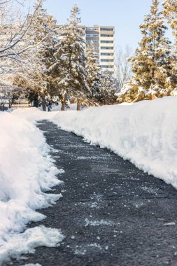 Karları eritmek için tuzlu kış yolu ve arka planda apartman.