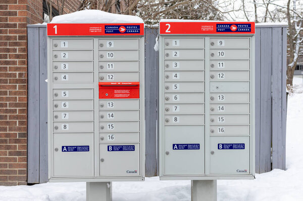Оттава, Канада - 17 января 2021 года: почтовый ящик Canada Post с красным знаком на английском и французском языках рядом с домом в зимний сезон