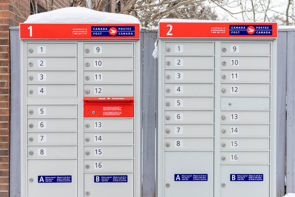 Оттава, Канада - 17 января 2021 года: почтовый ящик Canada Post с красным знаком на английском и французском языках рядом с домом в зимний сезон