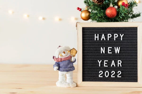 Happy new year 2022 greetings on letter board and Christmas tree with holiday decorations on table — Stock Photo, Image