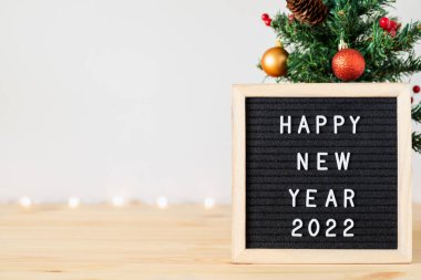 Yeni yılınız kutlu olsun. Masada Noel ağacı ve mektup tahtası var.