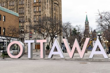 Byward Market 'teki Ottawa tabelasının arkasında Kanada Parlamentosu var..