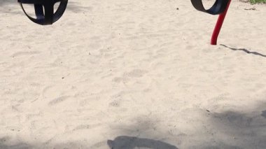 Bir yaz günü parkta çocuksuz salıncaklar.