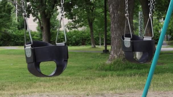 Houpačky na hřišti v parku bez dětí v létě — Stock video